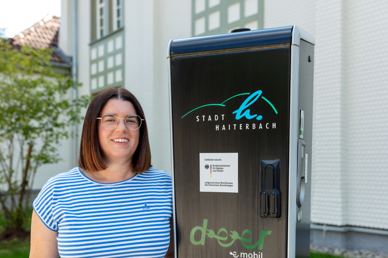 Kerstin Brenner an einer Ladesäule für Elektrofahrzeuge